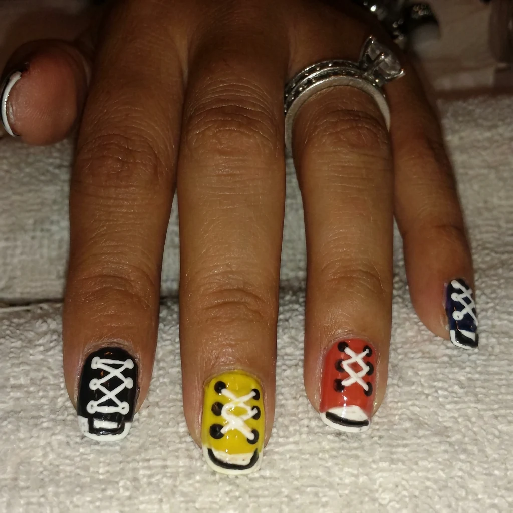 Manicura con diseño artístico en negro y amarillo